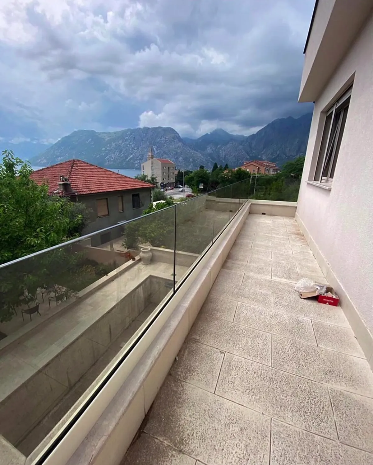 Staklena ograda na terasi sa pogledom na zaliv i planine